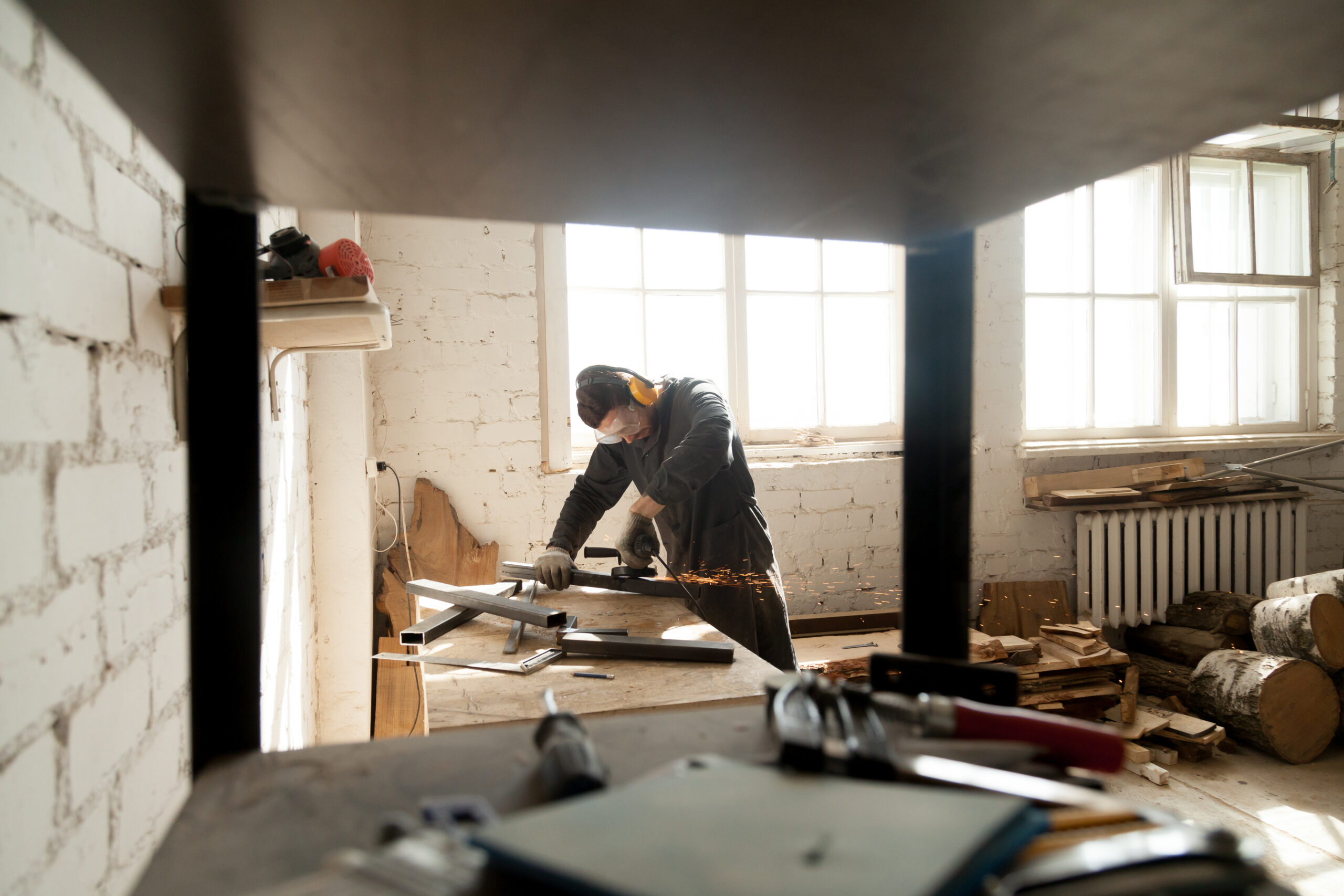 Manual worker grinding metal steel objects in workshop with tool Man Working