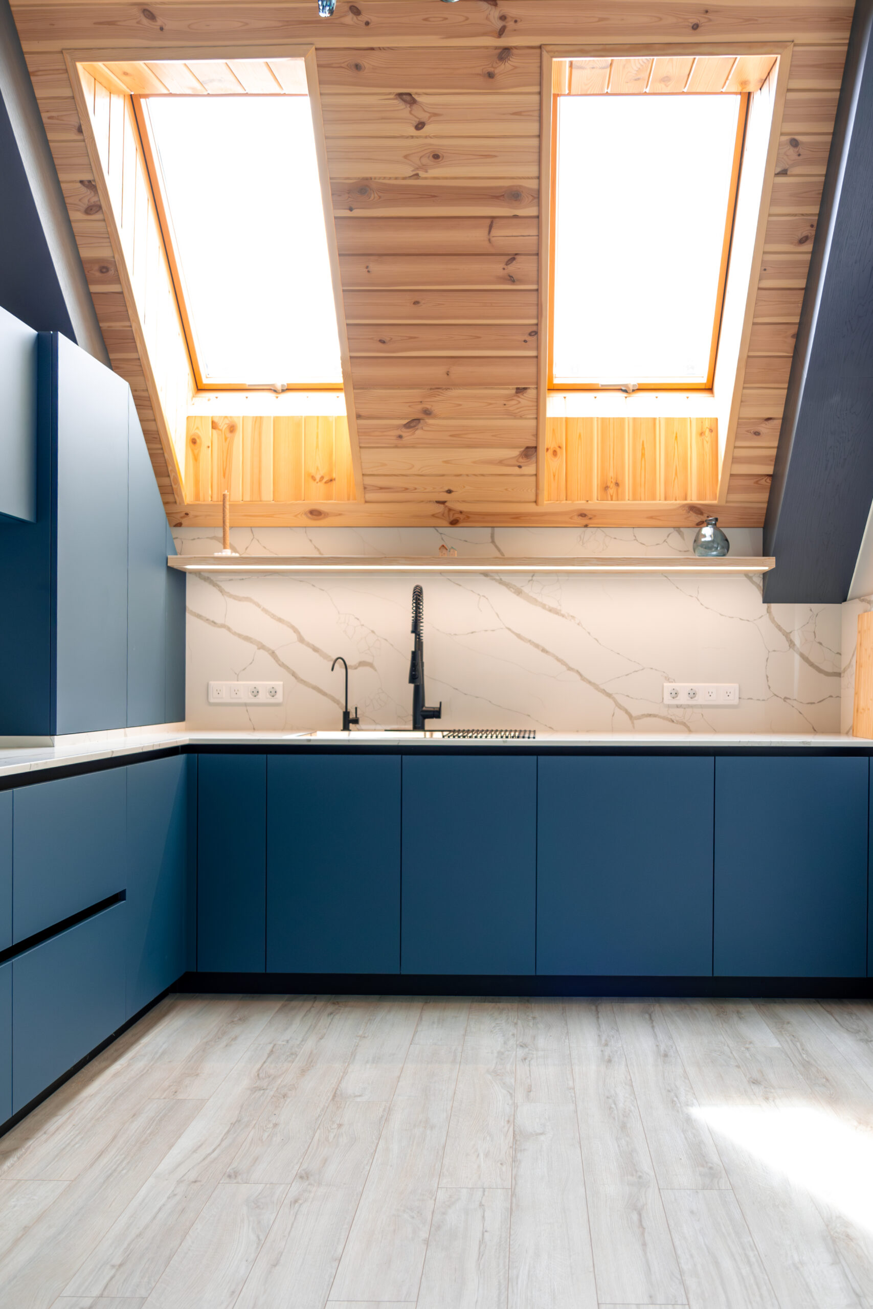 Attic minimal kitchen. Blue fronts. Bright marble kitchen flooring